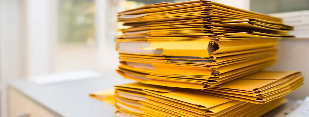 Pilha de pastas amarelas com documentos sobre uma mesa